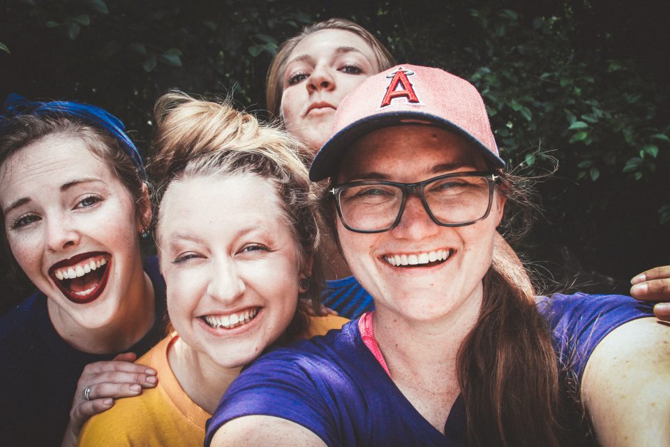 Vier Freundinnen nehmen ein Selfie auf und lachen dabei.