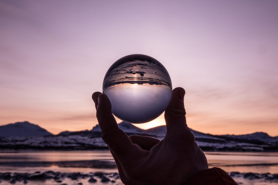 Glaskugel vor einer Landschaft.