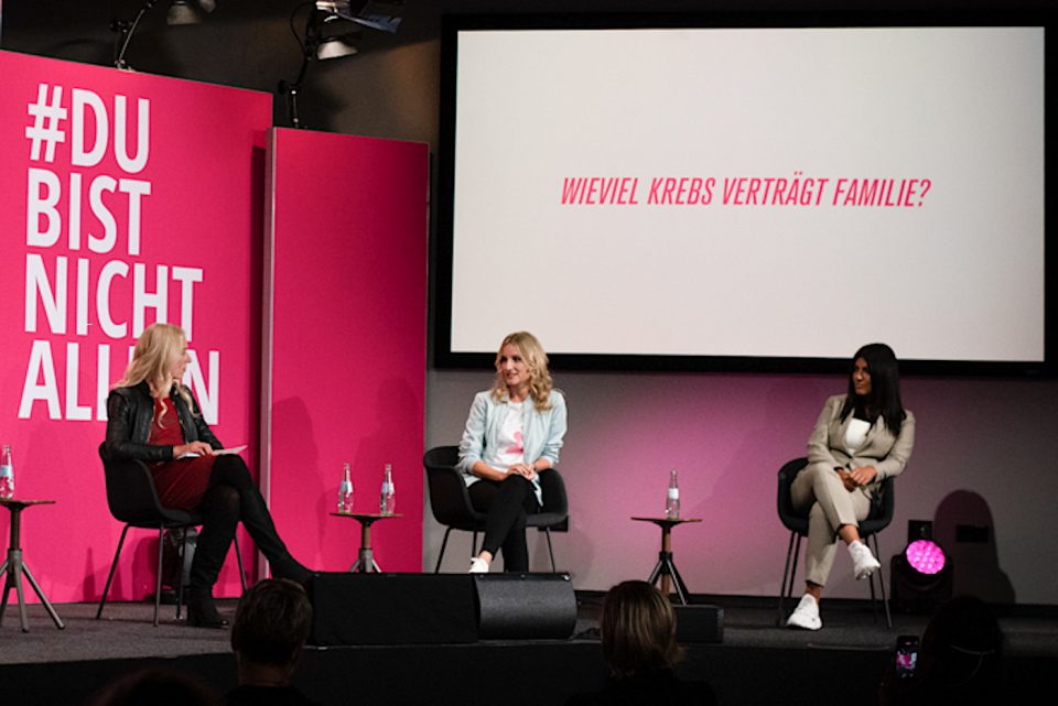 Drei Frauen bei einer Podiumsdiskussion.