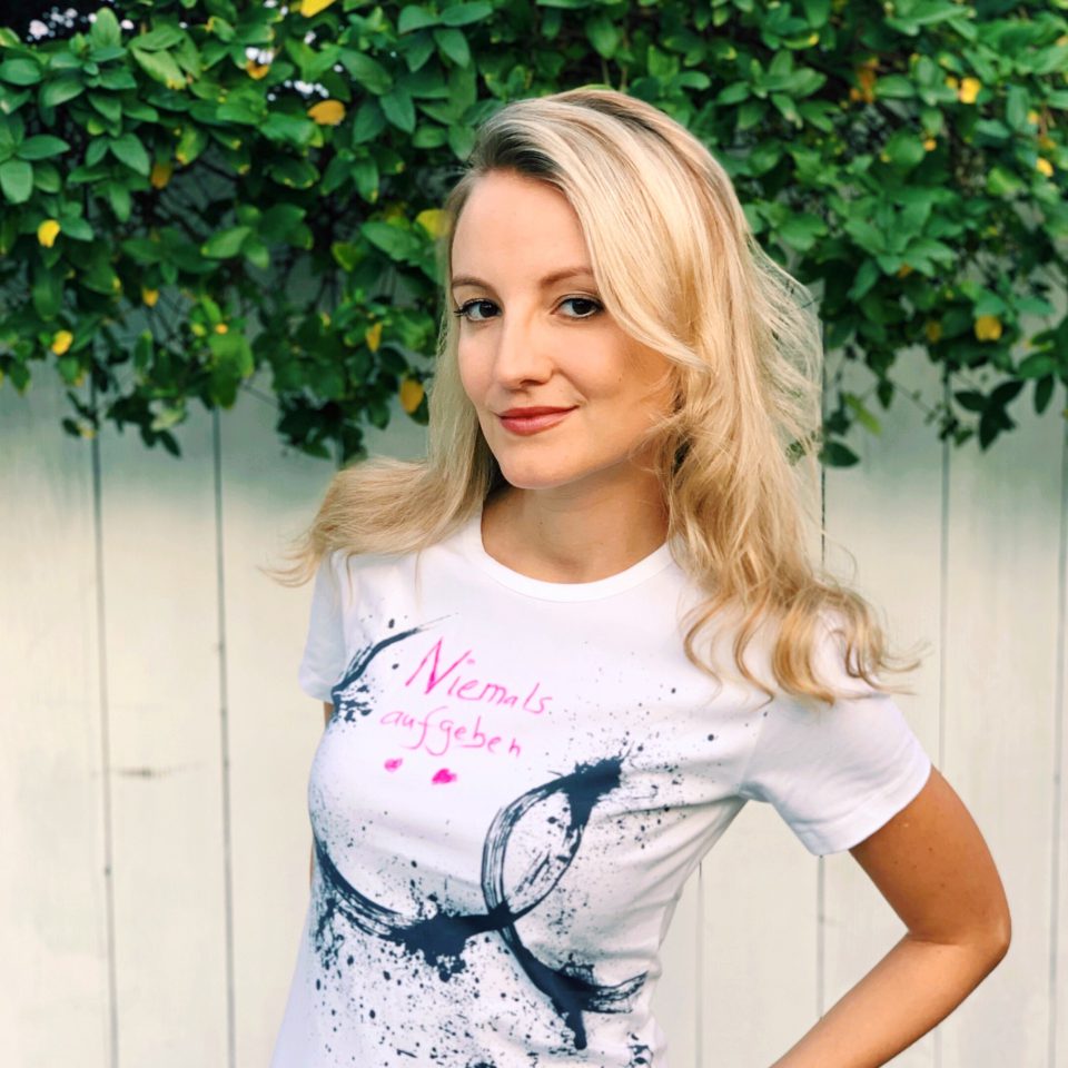 Blonde Frau mit T-Shirt mit der Aufschrift „Niemals aufgeben“. Blonde Frau mit T-Shirt mit der Aufschrift „Niemals aufgeben“.