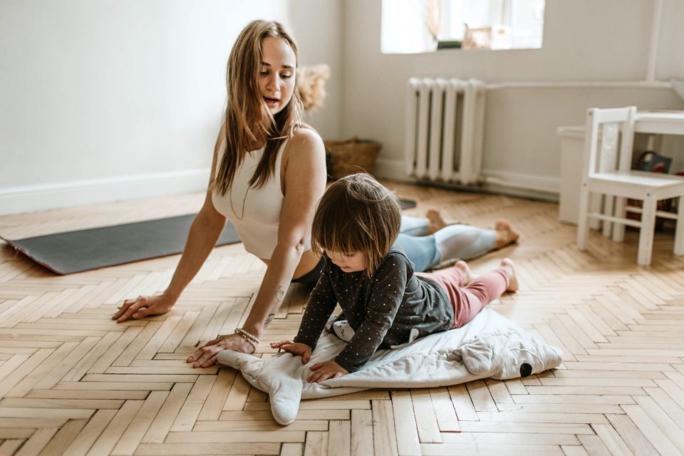 Frau mit Kind, die Yoga machen.