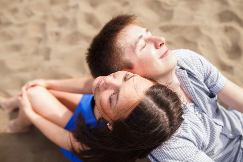 A Young Couple Walks Along The Beach 