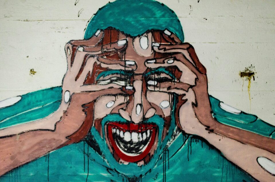 Streetart Mann fasst sich an Kopf Schmerz