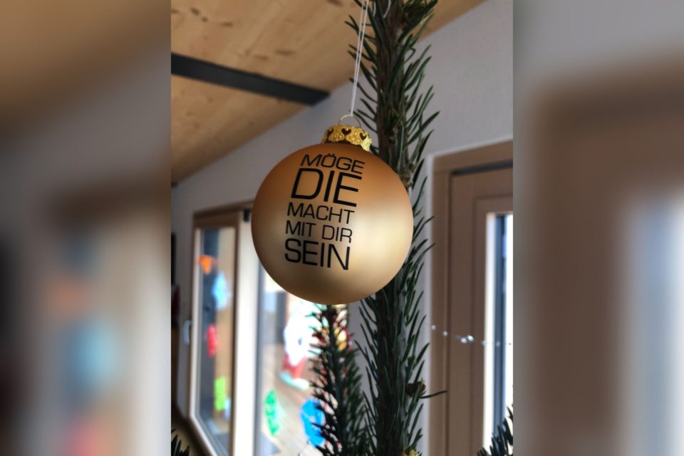 Goldene Weihnachtsbaumkugel mit der Aufschrift „Möge die Macht mit dir sein“.