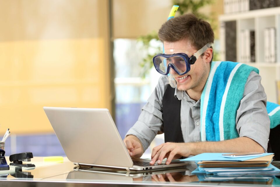 Mann mit Taucherbrille sitzt vor einem Laptop.