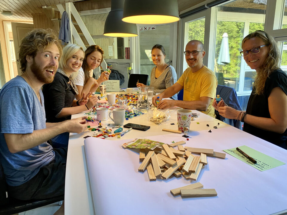 Das Kurvenkratzer-Team sitzt zusammen am Tisch beim Lego Serious PlayD Cbf A D _