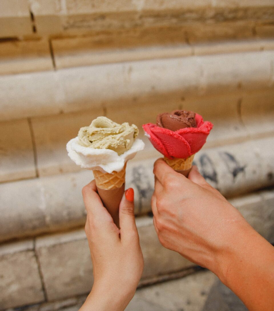 zwei haende halten zwei eistueten mit einem weissen und einem roten eis pexels kristina paukshtite