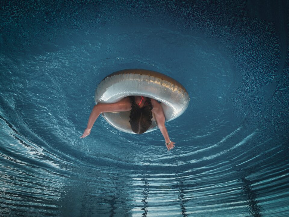 Auf dem Kopf stehendes Foto einer Frau im Wasser mit Schwimmreifen