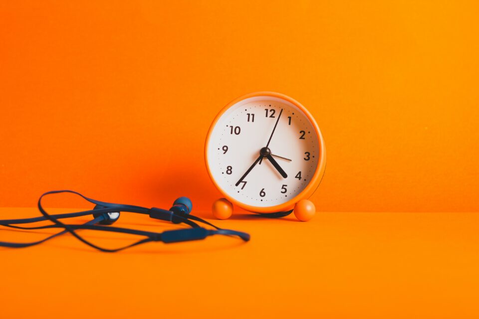 Orangener Hintergrund mit einer Uhr in der Mitte