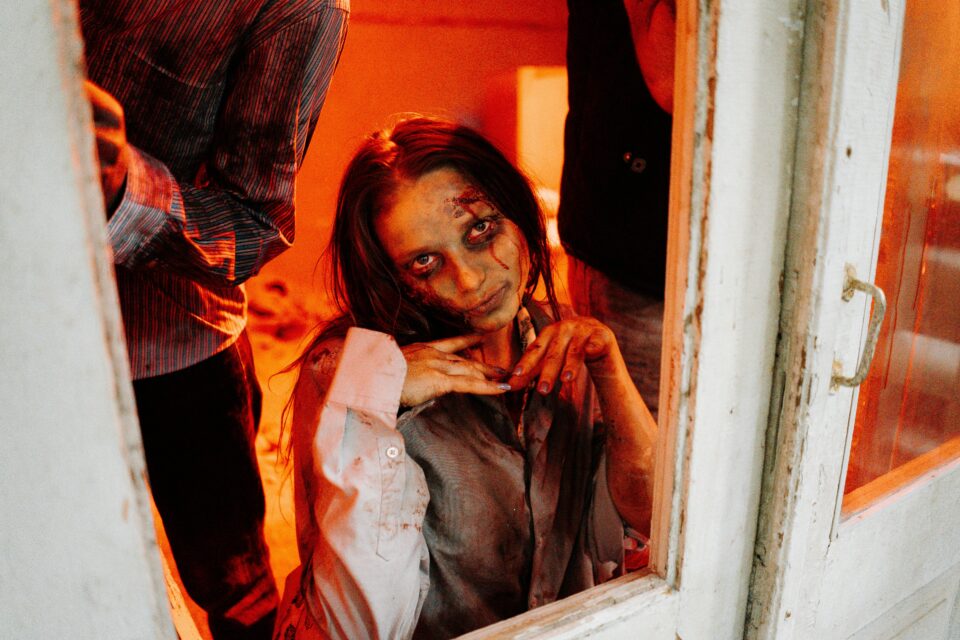 Frau in einem Zombiekostüm posiert für die Kamera