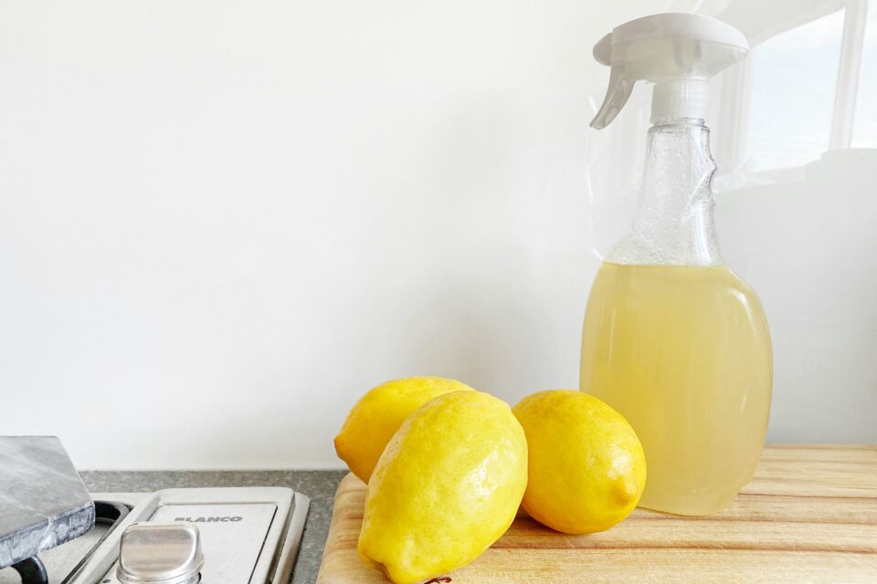 Zitronen auf einem Küchenbrett mit einer Sprayflasche