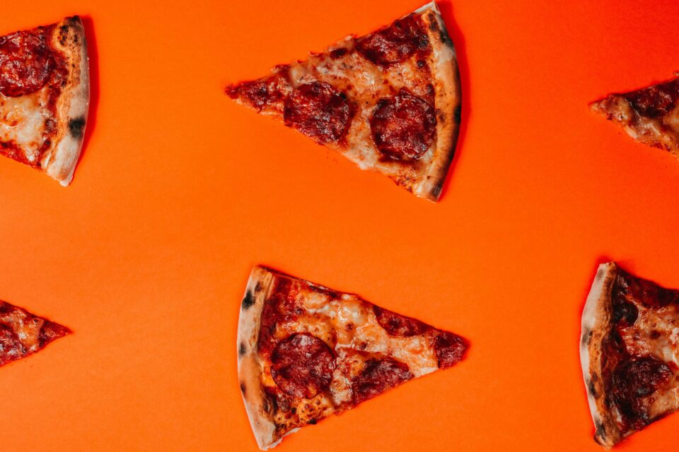 Pizzaschnitten mit orangenem Hintergrund
