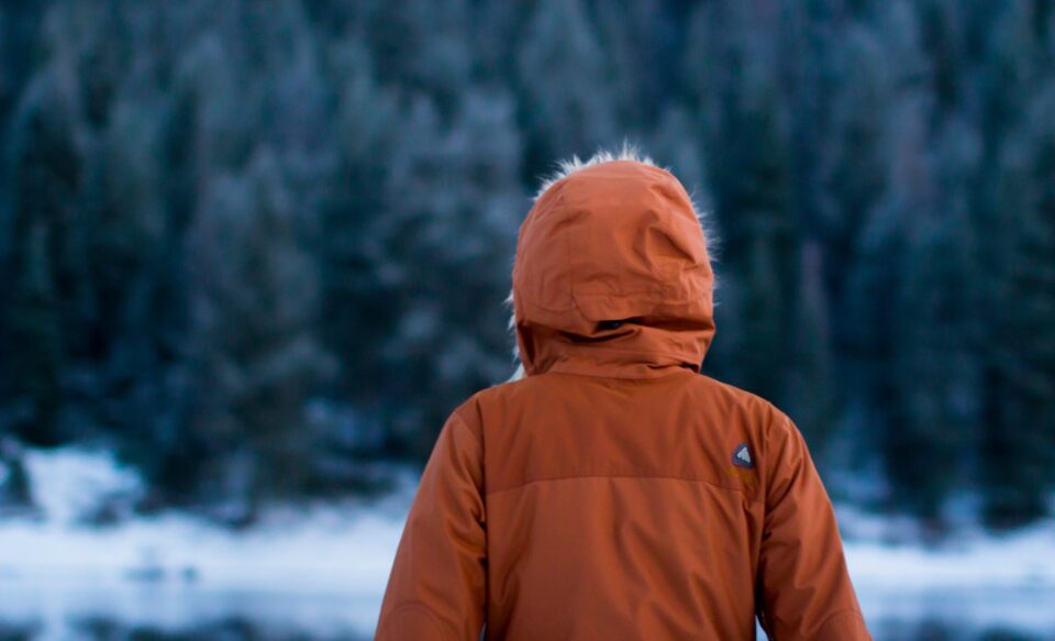 Person von hinten mit orangebrauner Winterjacke