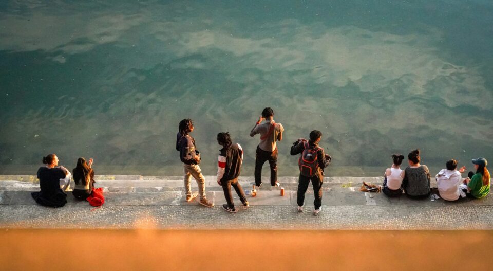 Menschen sitzen am Wasser