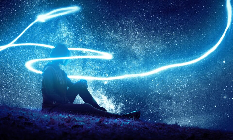 Person sitzend Nacht Sternenhimmel in Lichtwirbel