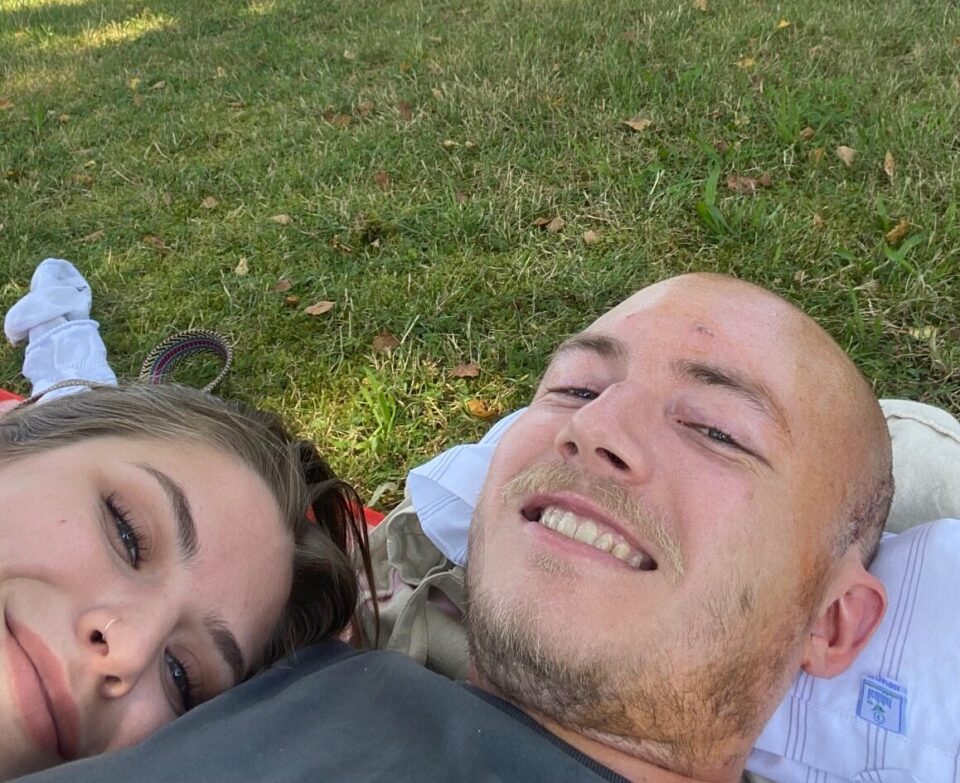 Mann hält Frau im Arm liegend im Park