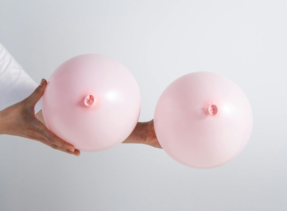 zwei rosa Luftballons werden gehalten