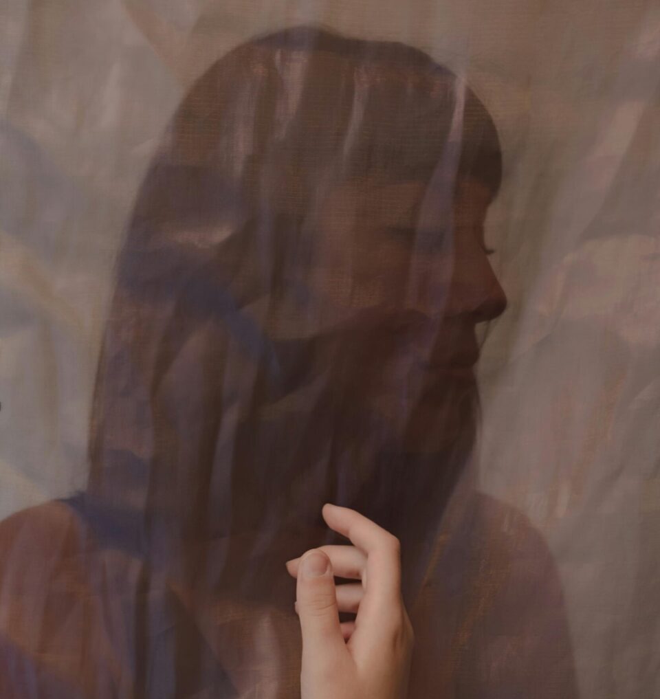 Bild von Frau in braunen Farbtönen wie hinter einem Schleier