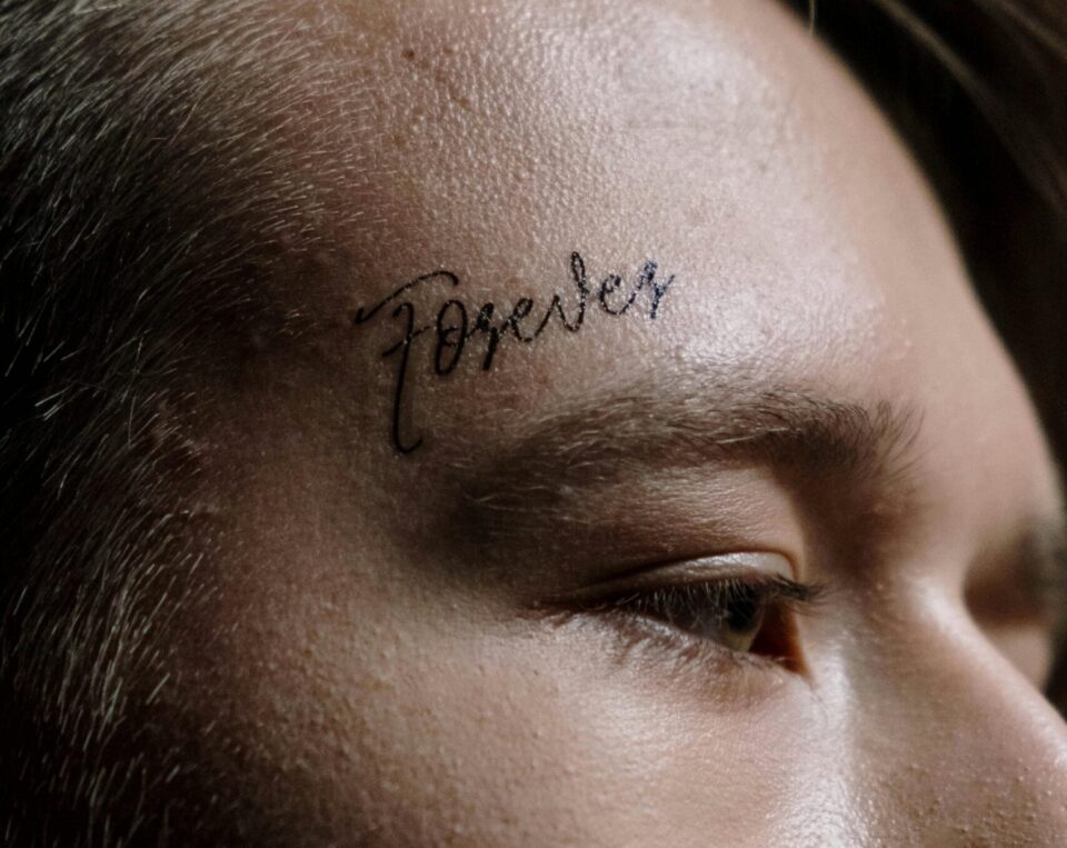 Wort auf Schläfe tätowiert