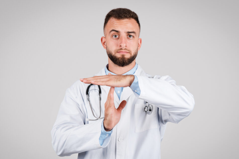 Doctor Gesturing Time Out, Grey Background