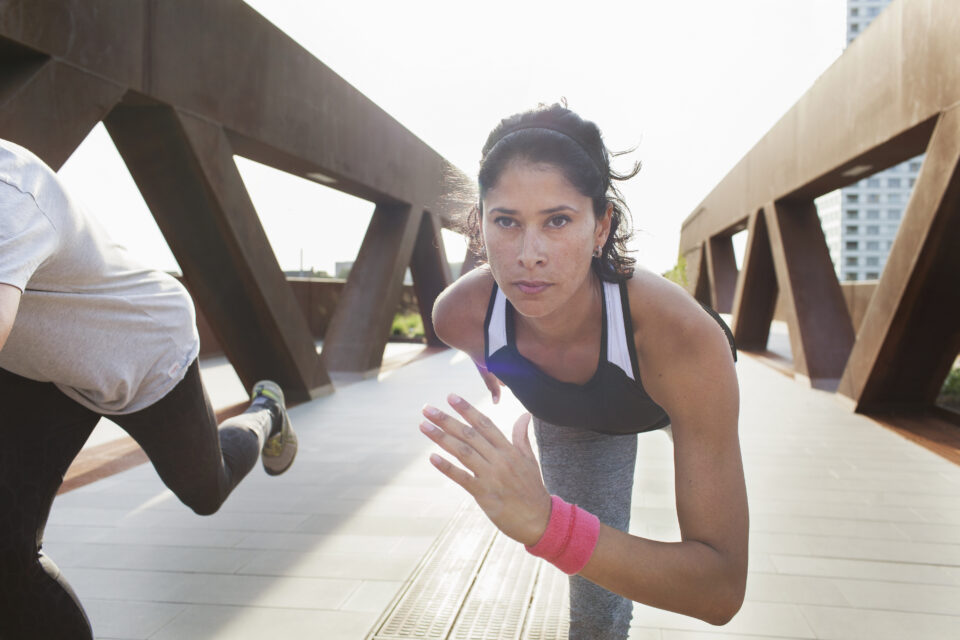 Woman Training On One Leg On Urban Footbridge